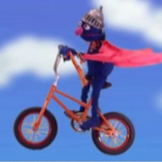 627299049a3dc_61e4e31d882b9_Grover-flying-on-bikejpg.png